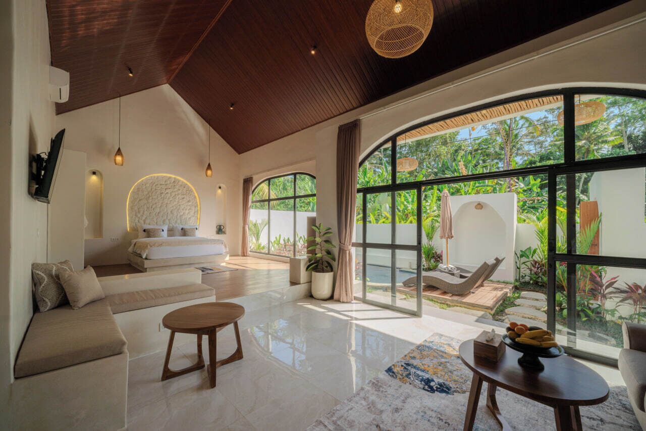 A modern interior with a large window, a sofa, a dining table, and a hammock outside.