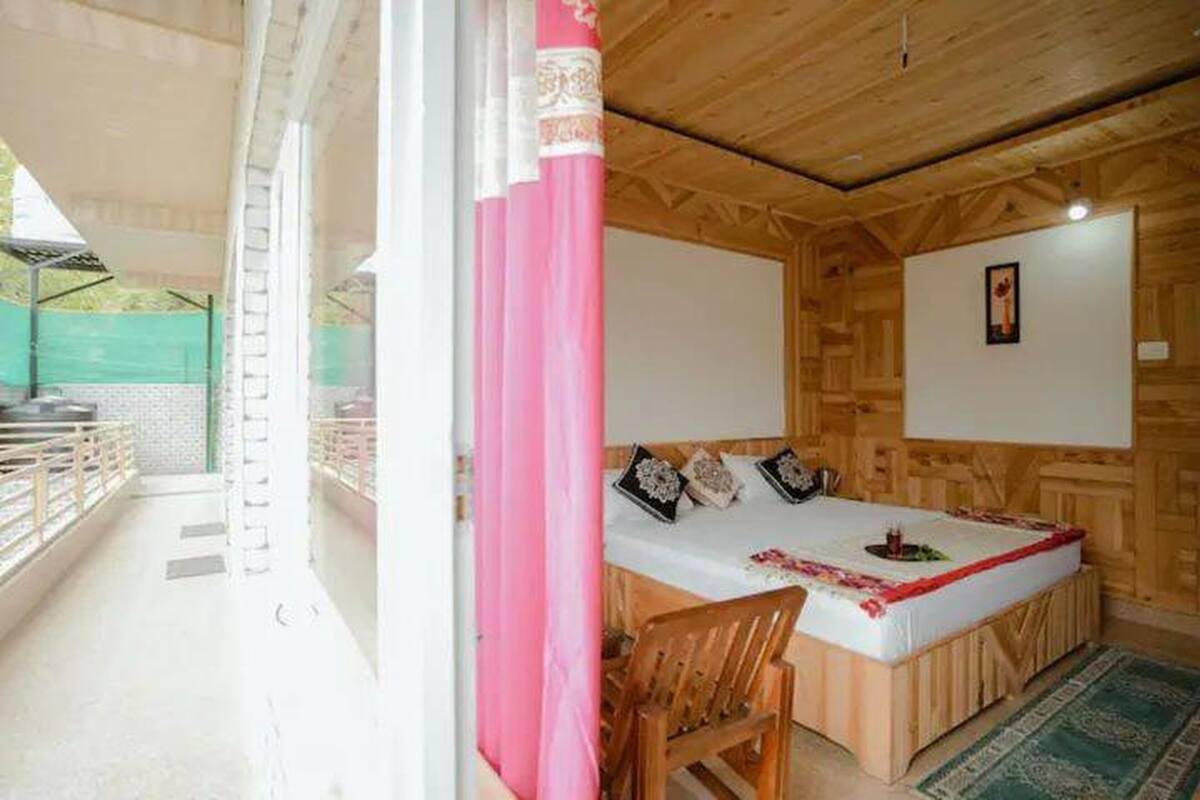 A wooden cabin with a bed, a chair, and a small table.