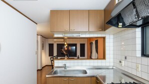Una cucina moderna con mobili in legno, un lavello in acciaio inossidabile e un piano cottura a gas.