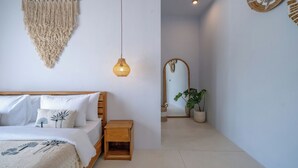 Ein Schlafzimmer mit Bett, Nachttisch und einer Wanddekoration aus Makramee.