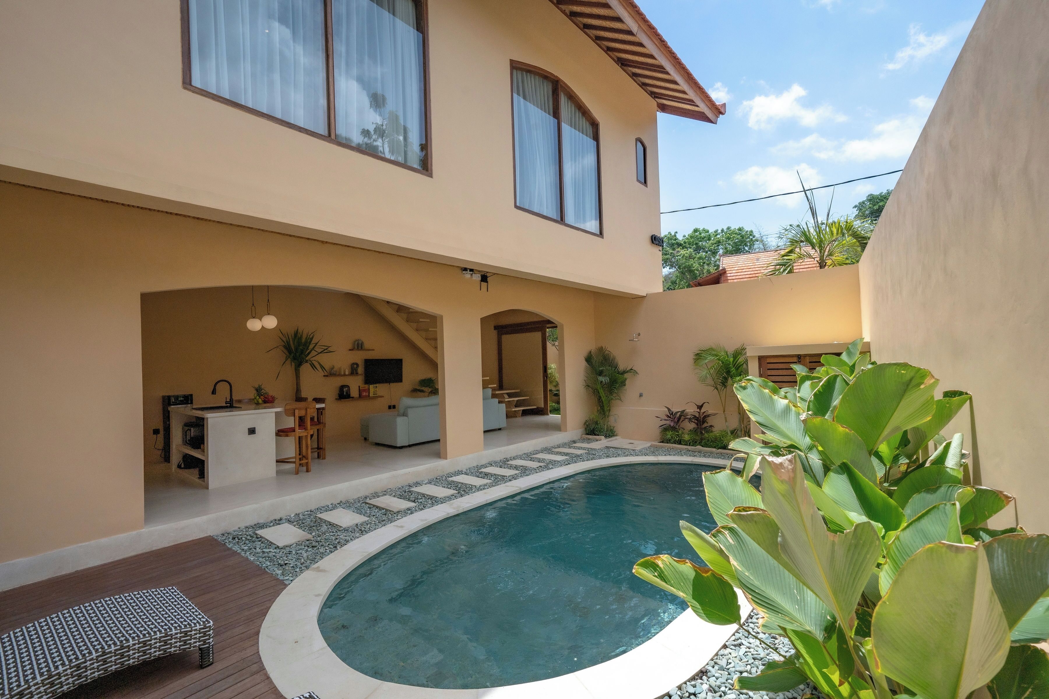 A modern house with a swimming pool, a covered patio, and a kitchen area.