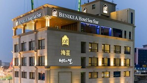 Een meerlaags hotel met een opvallend bord waarop 'Benikea Hotel Sea Star' staat.