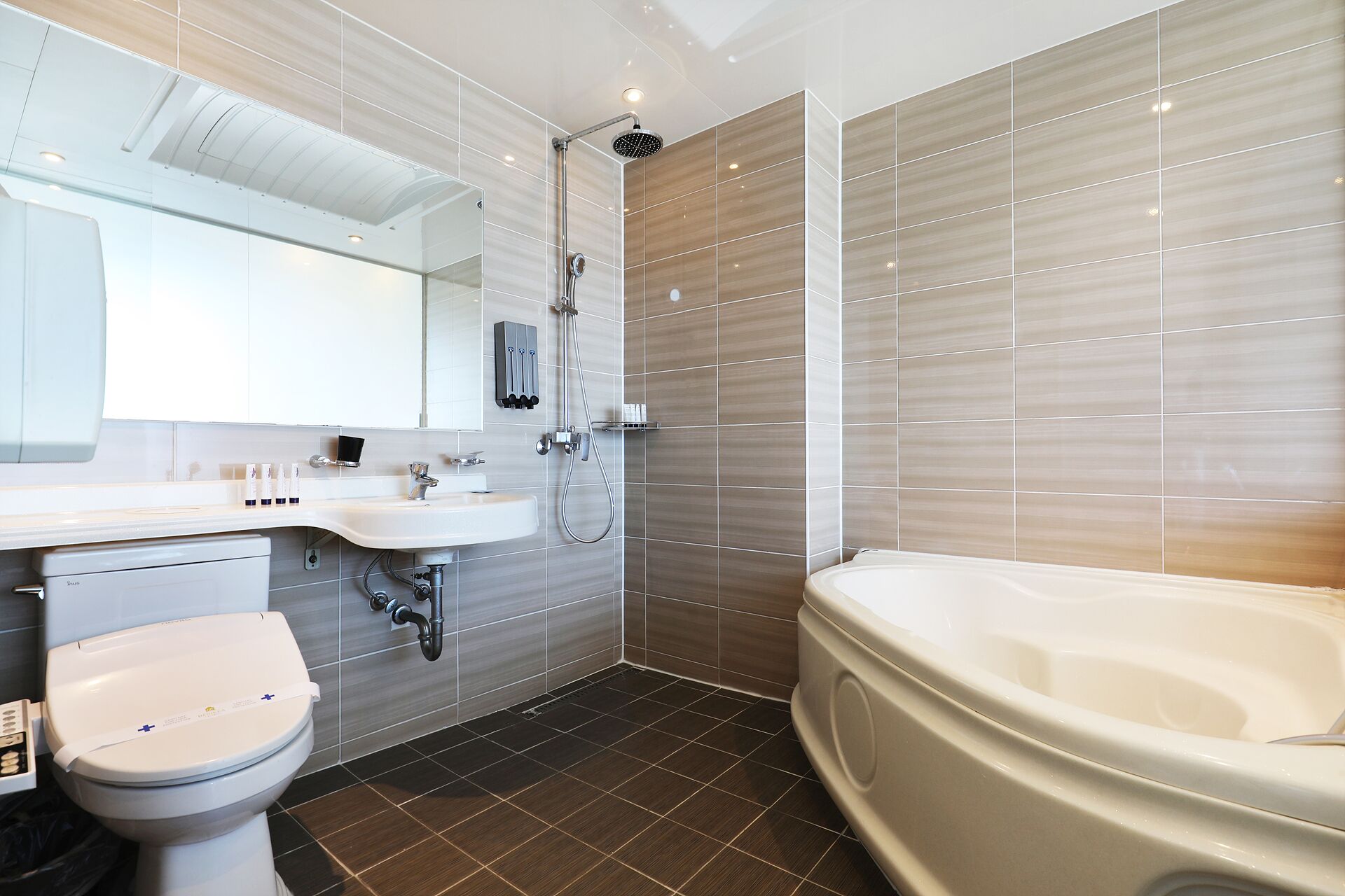 Een moderne badkamer met toilet, wastafel en bad.