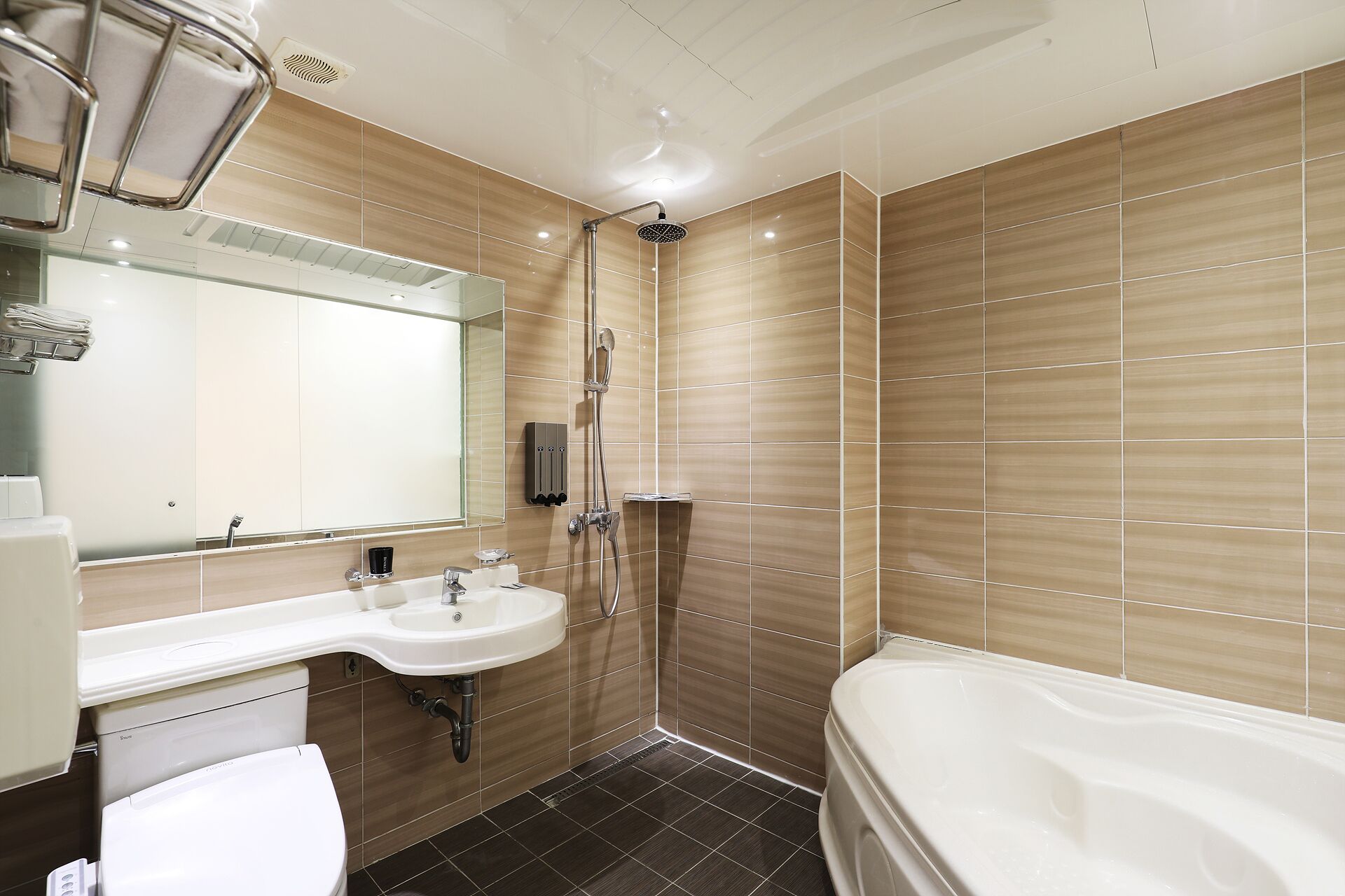 A modern bathroom with a large mirror, a sink, a shower, and a bathtub.