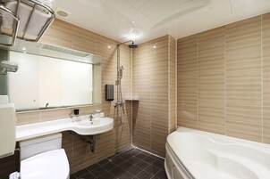 Une salle de bain moderne avec un grand miroir, un lavabo, une douche et une baignoire.