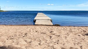 A wooden pier extending into calm blue waters from a sandy beach. - 6 Person Holiday Home in Hagby (Ljungbyholm)