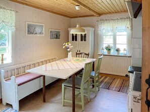 A dining area with a table set for two, a bench, and a radiator. - 6 Person Holiday Home in Hagby (Ljungbyholm)
