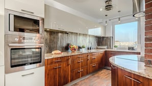 Una cocina moderna con electrodomésticos de acero inoxidable, armarios de madera y un ventanal con vistas.