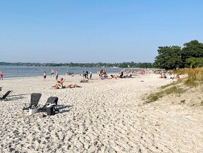 A sandy beach with lounge chairs and umbrellas, a clear sky, and a calm sea. - 6 Person Holiday Home in Borgholm (Borgholm)