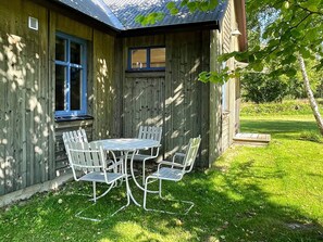 A wooden house with a covered patio and a table with chairs. - 6 Person Holiday Home in Borgholm (Borgholm)