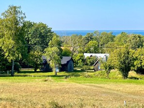 A rural landscape with houses, trees, and a clear view of the ocean. - 6 Person Holiday Home in Borgholm (Borgholm)