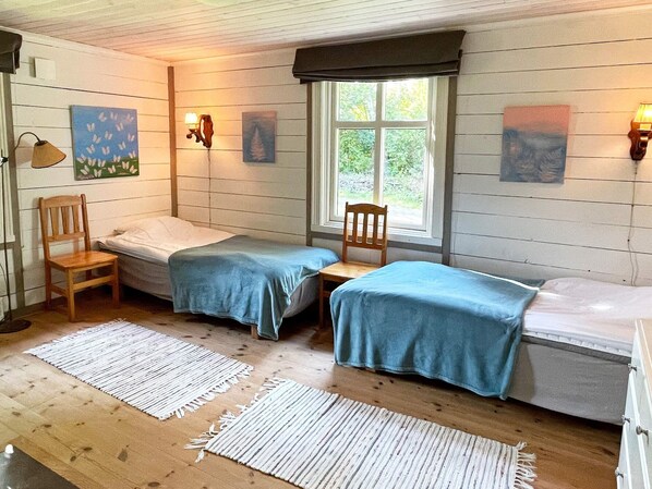 A room with two beds, wooden flooring, and a window with a view. - 6 Person Holiday Home in Borgholm (Borgholm)