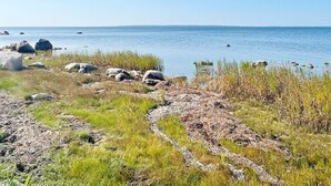 A coastal landscape with a clear sky, rocky terrain, and a body of water. - 6 Person Holiday Home in Borgholm (Borgholm)