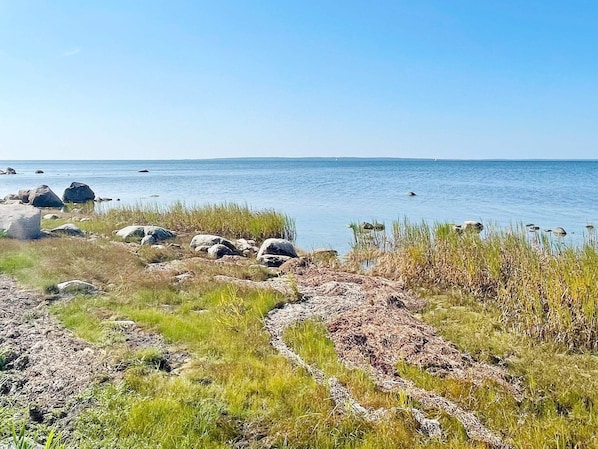 A coastal landscape with a clear sky, rocky terrain, and a body of water. - 6 Person Holiday Home in Borgholm (Borgholm)