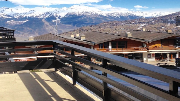 A mountain lodge with a balcony overlooking snow-capped peaks. - Apartment in Veysonnaz Near Ski Gondola (Veysonnaz)