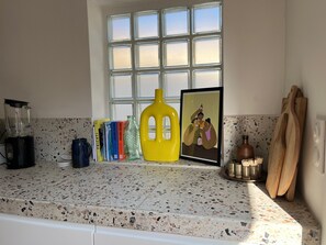 Kitchen counter with a blender, vase, framed picture, and books.