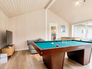 A room with a pool table, a sofa, a television, and a foosball table. - 5 Star Holiday Home in Vaeggerlose (Vaeggerlose)