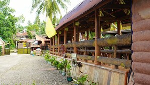 Un bâtiment en bois doté d’un porche couvert et d’une allée gravillonnée.
