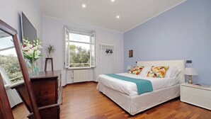 Ein Schlafzimmer mit Bett, Nachttisch und Fenster.