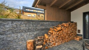 Een modern gebouw met een stenen muur en een stap houtblokken.