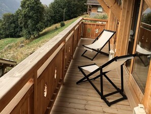 A wooden deck with two lounge chairs and a view of a mountainous landscape. - Luxury Chalet With Sauna and Garden (Vex)