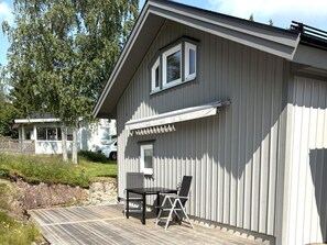 A building with a covered outdoor seating area, a window, and a garage door. - 4 Person Holiday Home in Frandefors (Frändefors)