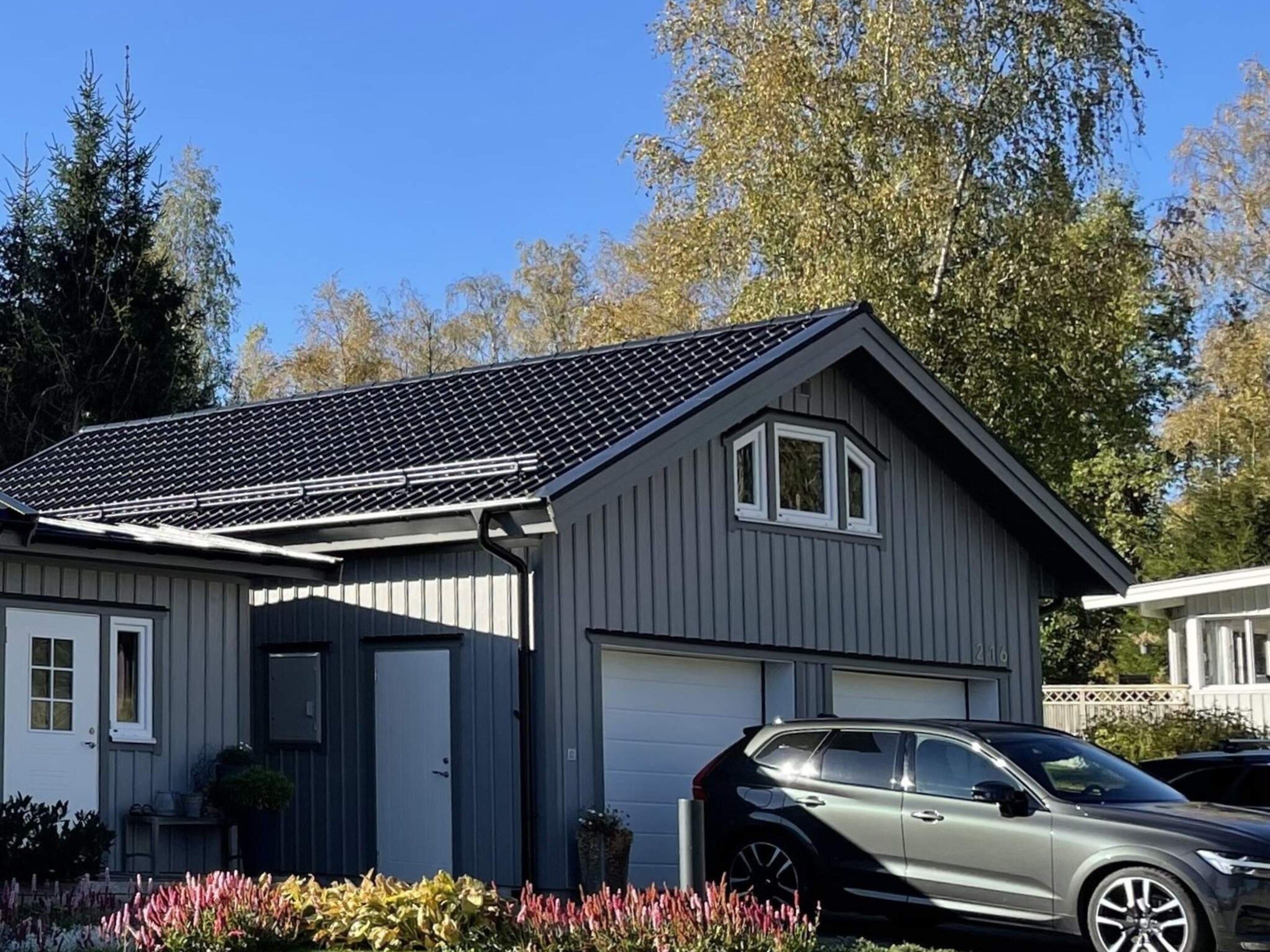 A single-story house with a garage, a car parked in front, and a well-maintained garden.