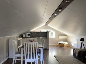 A compact living space with a dining area, kitchenette, and a cozy seating area with a sofa and a lamp. - 4 Person Holiday Home in Frandefors (Frändefors)