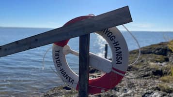 A lifebuoy attached to a wooden post by the sea.