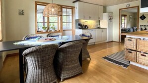 A modern kitchen with white cabinets, a black countertop, and wicker chairs. - 4 Star Holiday Home in Valdemarsvik (Valdemarsvik)