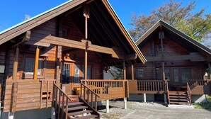 Deux cabanes en bois, chacune dotée d’un porche et d’un escalier menant à l’entrée.