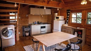 L’intérieur d’une cabane en bois comprend une cuisine, un coin repas et un lave-linge.