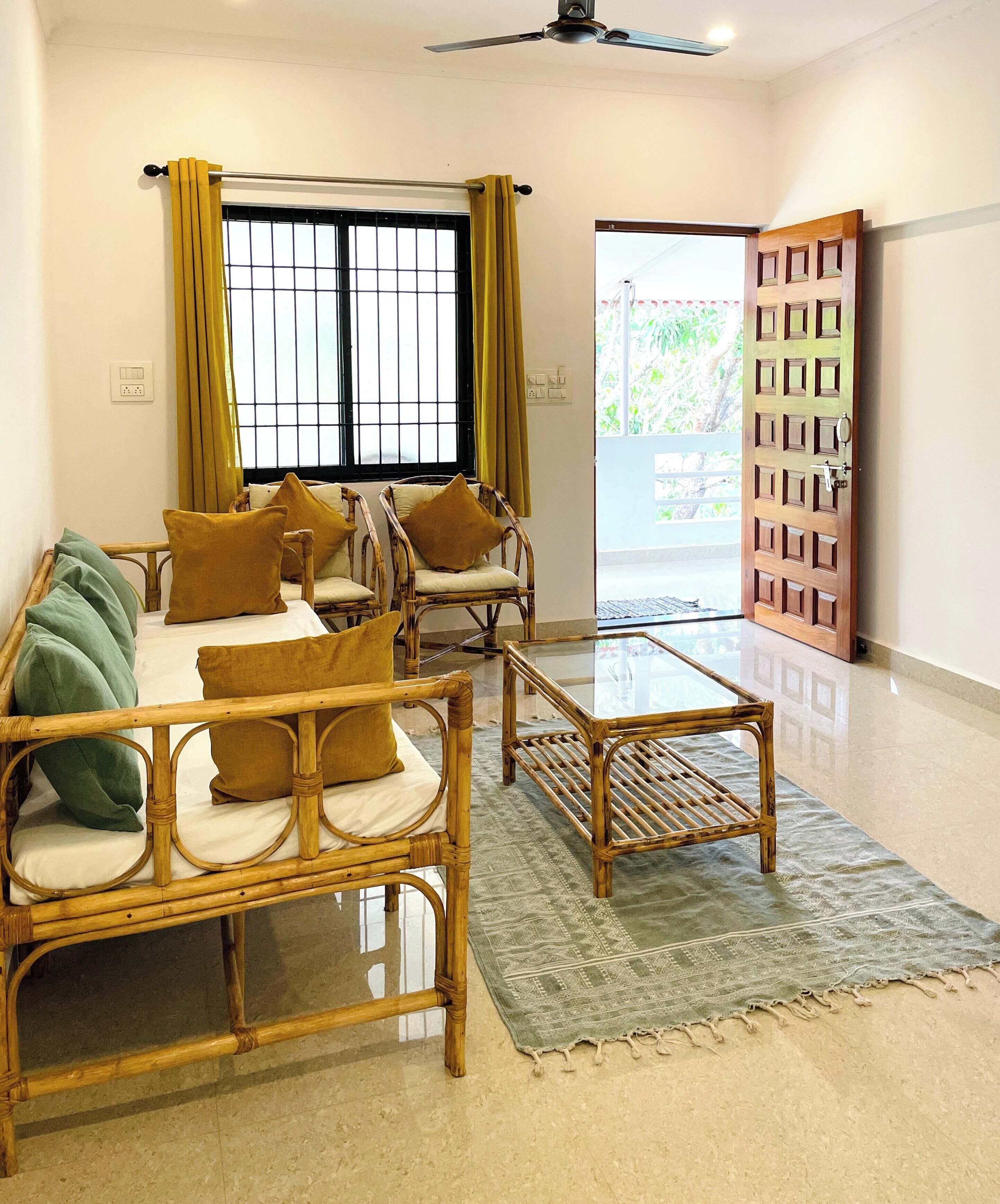 A room with a sofa, two armchairs, a coffee table, and a view of the outdoors through a window.