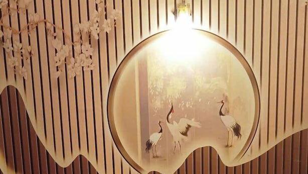 Une chambre d’hôtel avec un lit, un miroir décoratif et une table de chevet avec une lampe.