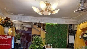 Un espace d’accueil doté d’un sol à motifs, d’un mur vert et d’une enseigne Coca-Cola.