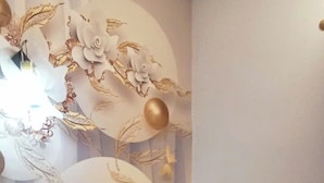 Une chambre d’hôtel avec un grand lit, une table de chevet, un bureau et un mur décoratif.