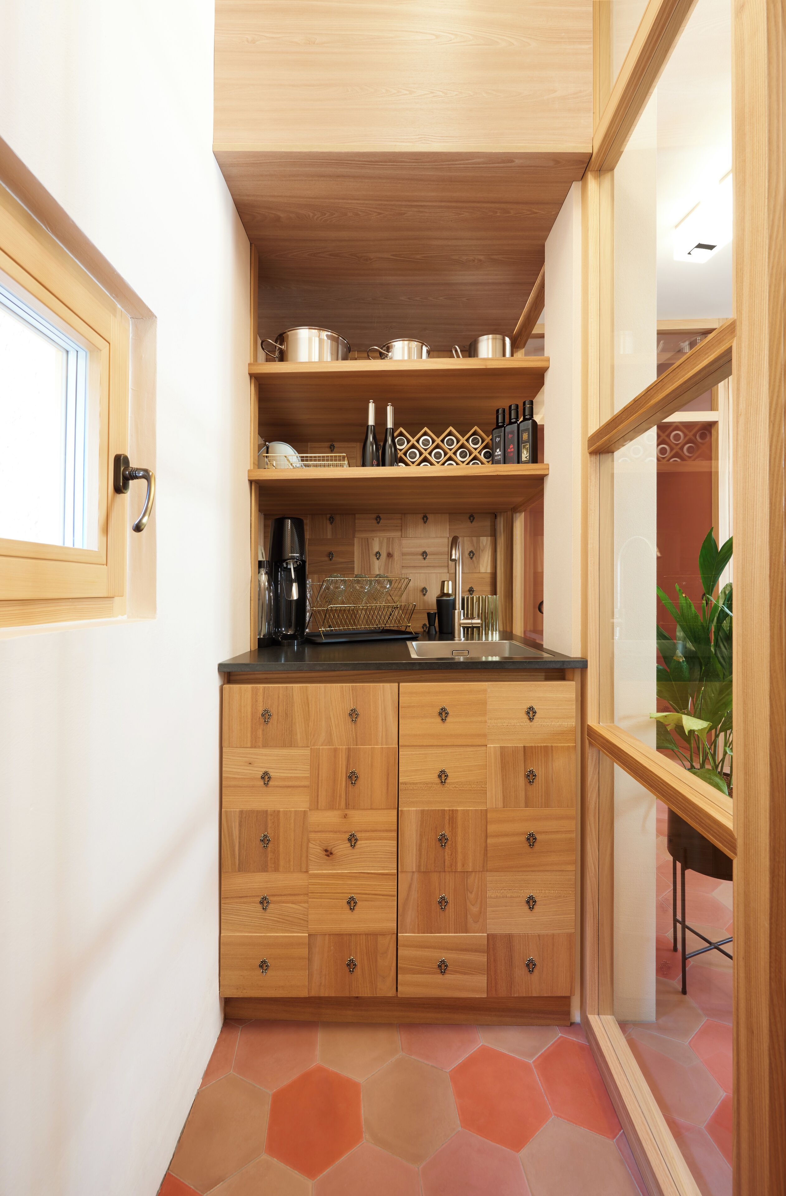 Eine kleine Küche mit Holzausstattung, einer Arbeitsplatte und einem Spülbecken.