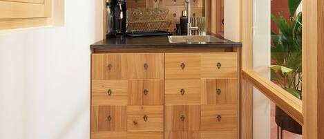 A compact kitchen with wooden cabinets, a countertop, and a sink.