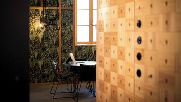 Una habitación con pared de madera, una ventana y una mesa con sillas.