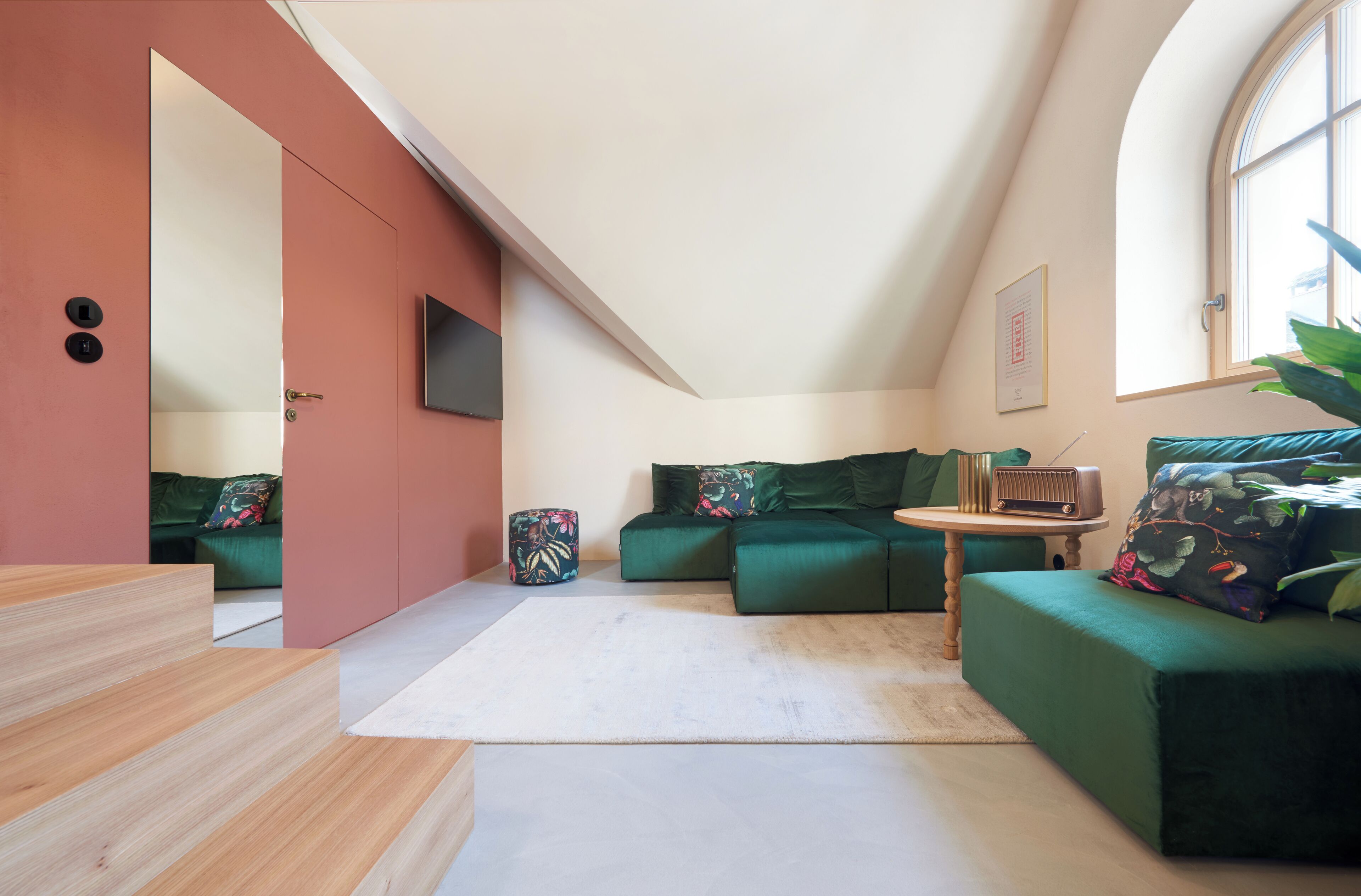 A modern living room with a green sofa set, a wooden coffee table, and a small side table.