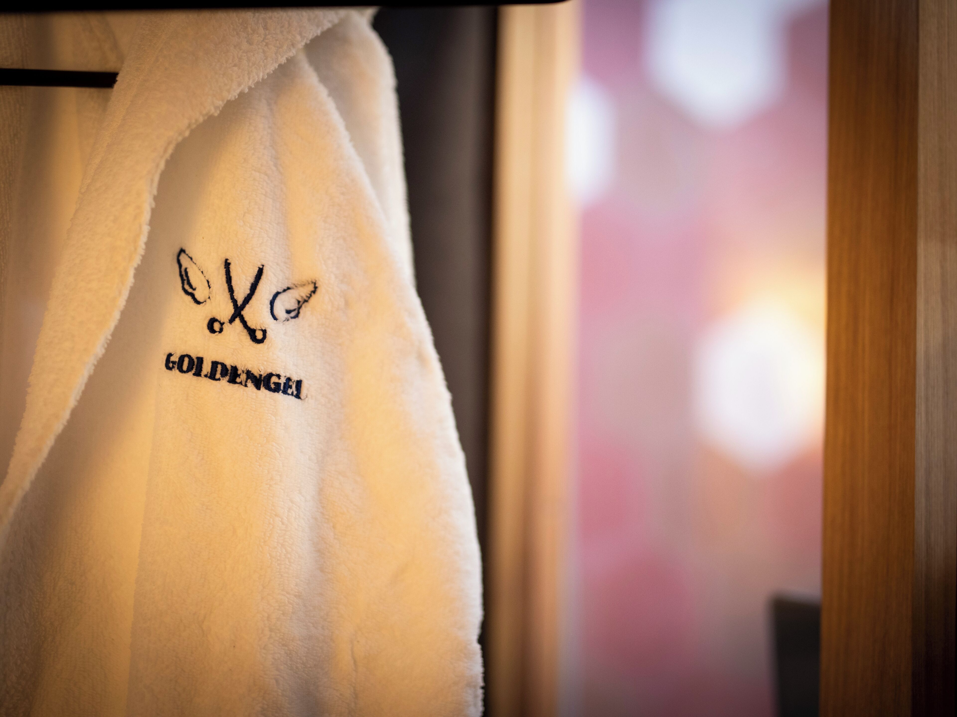 A white towel with embroidered text and a logo on a window sill.
