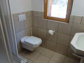 A small bathroom with a toilet, a window, and a sink. - Spacious Apartment With Firepllace (Veysonnaz)