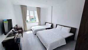 A hotel room with two beds, a desk, a chair, a TV, and large windows with curtains. - Ha Bao Chau Hotel Tan Binh (Ho Chi Minh City)