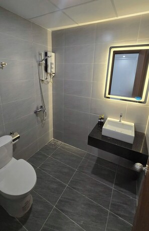 Deluxe tweepersoonskamer | Badkamer | Een douche, pantoffels, handdoeken, zeep