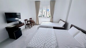 A hotel room with two beds, a desk with a TV, and a chair. - Ha Bao Chau Hotel Tan Binh (Ho Chi Minh City)