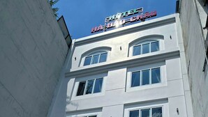 A multi-story hotel with a white facade, multiple windows, and a sign indicating it is a hotel. - Ha Bao Chau Hotel Tan Binh (Ho Chi Minh City)