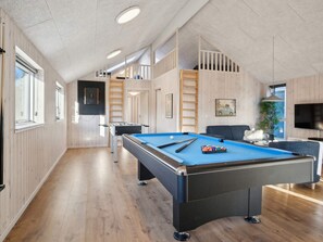 A pool table in a room with wooden floors and walls, a sofa, and a television. - 5 Star Holiday Home in Romo (Rømø)