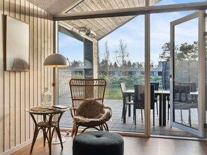A room with a glass door leading to an outdoor patio with a table and chairs.