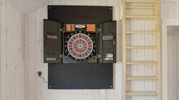 A dartboard mounted on a wall with a wooden ladder to its right.