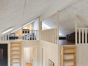 Ein Schlafzimmer im Loft-Stil mit Schräge, Holzbettkästen und einem Oberlicht.
